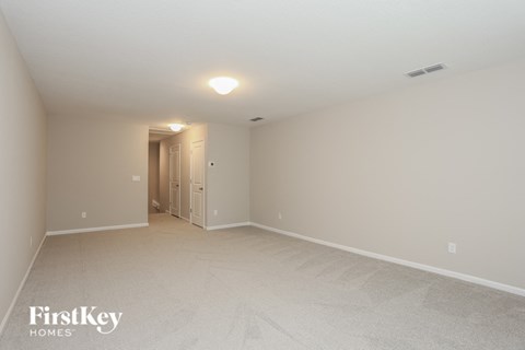 a spacious living room with white carpet and white walls