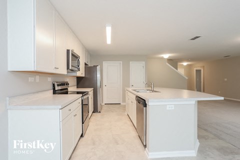 a large kitchen with white cabinets and stainless steel appliances