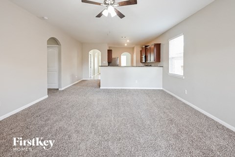 A spacious room with a fan and carpeted floor.