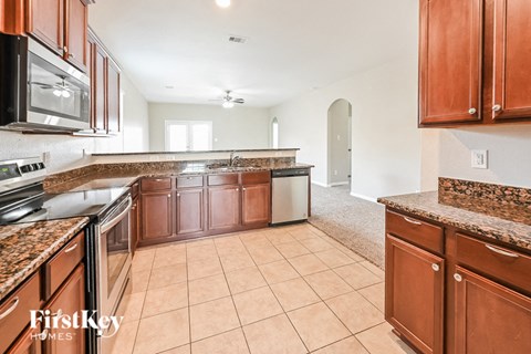 A kitchen with brown cabinets and a tile floor.