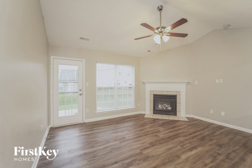 A room with a fireplace and a ceiling fan.