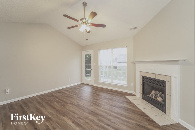 A room with a fireplace and a ceiling fan.