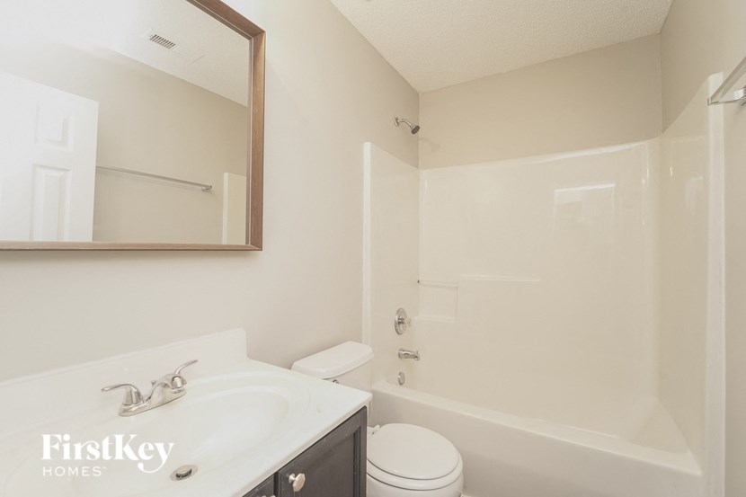 A white bathroom with a sink, toilet and bathtub.