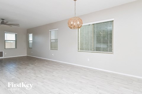 an empty living room with a ceiling fan and a window