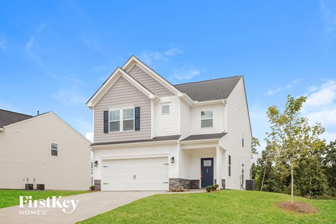 A two-story house with a garage is showcased in the image.