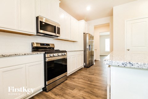 a kitchen with white cabinets and stainless steel appliances