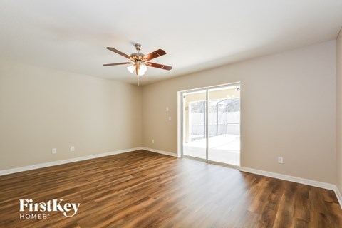 a living room with wood floors and a ceiling fan