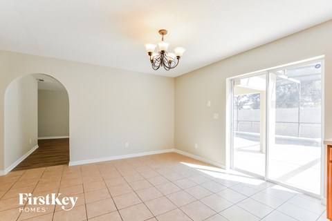a dining room with a large window and a door to a patio