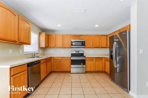 an empty kitchen with wooden cabinets and stainless steel appliances