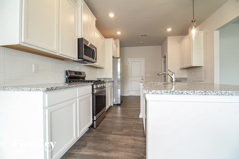 A kitchen with white cabinets and a black stove top oven.