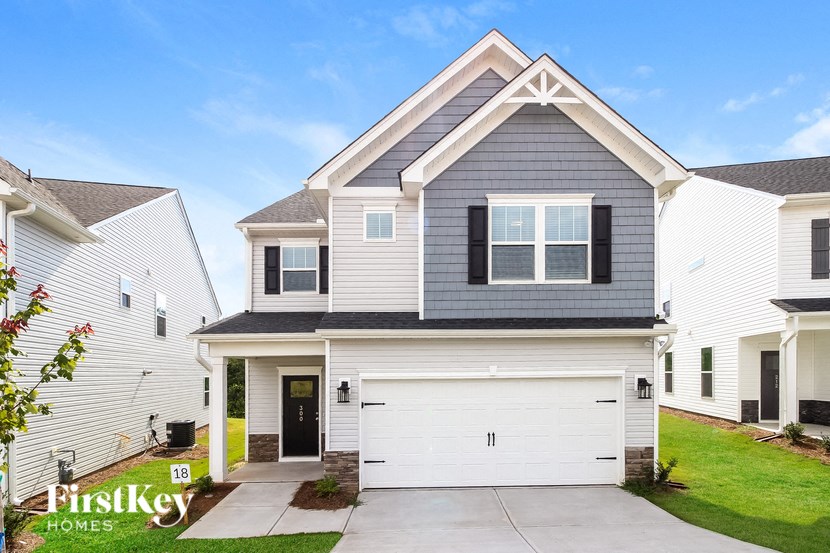 a white and gray house with a white garage door