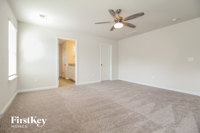an empty living room with a ceiling fan