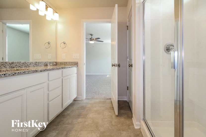 a bathroom with a shower and a sink and a mirror