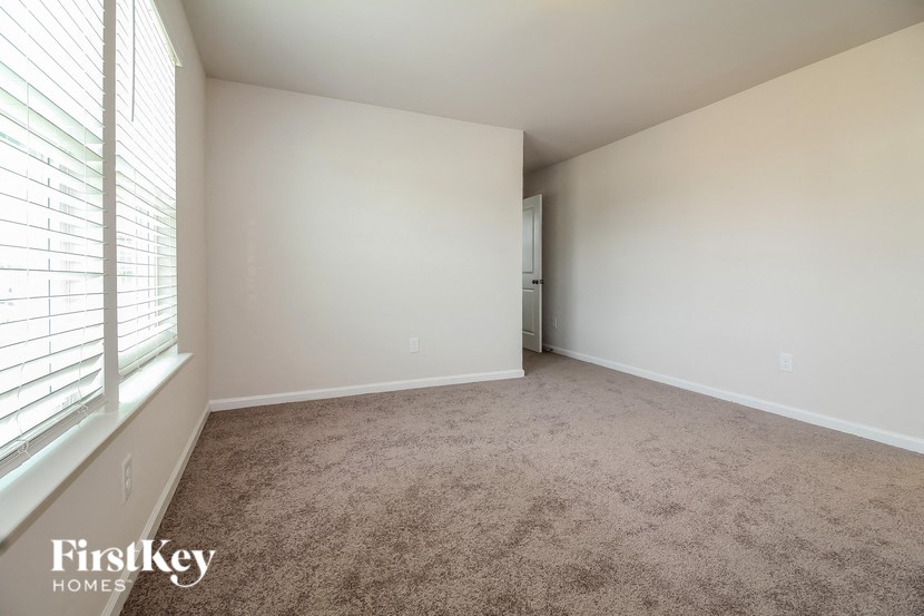 a bedroom with a carpeted floor and a large window