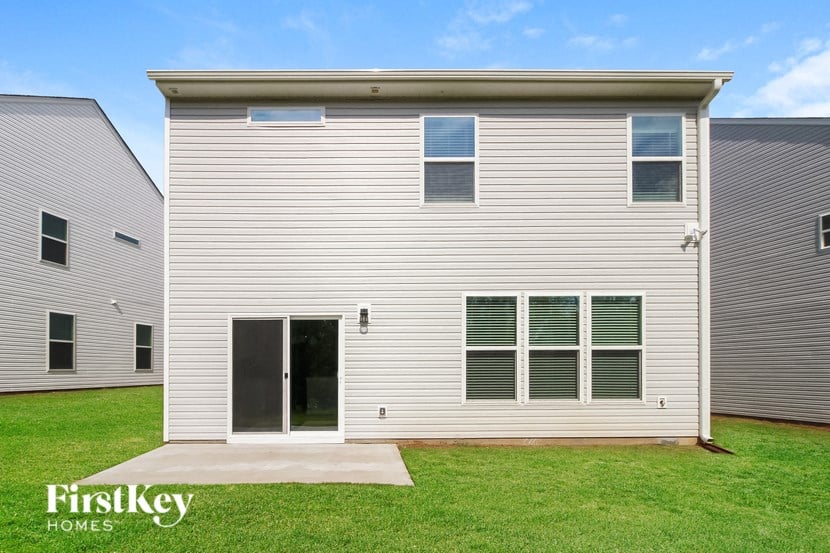 a white house with white siding and green grass