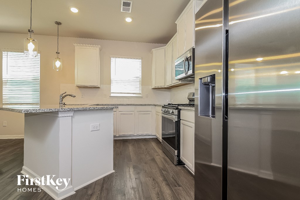 a kitchen with stainless steel appliances and white cabinets