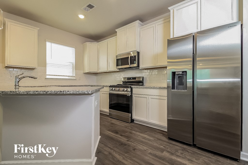 a kitchen with stainless steel appliances and white cabinets