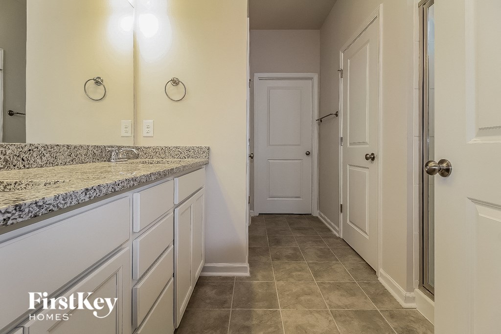 a kitchen with white cabinets and a counter top and a white door