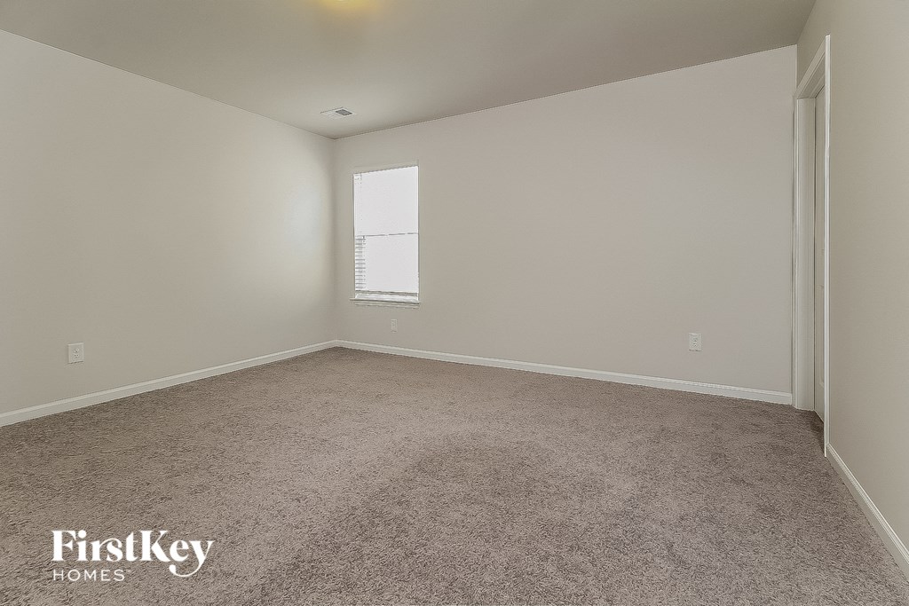 a bedroom with a carpeted floor and a window
