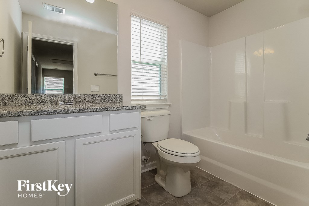 a bathroom with a toilet and a tub and a sink