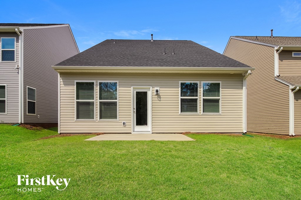 the front of a house with a grassy yard and two neighboring houses