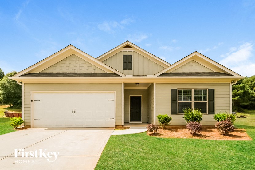 A two-story house with a garage and a driveway.