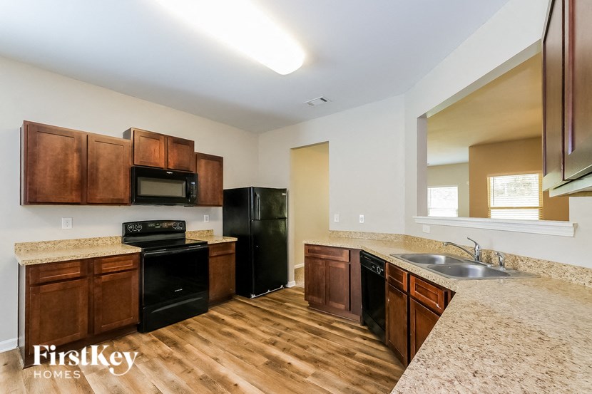 A kitchen with wooden cabinets and black appliances.