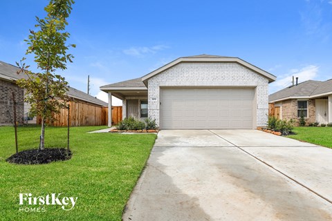 a white brick house with a driveway in front of it