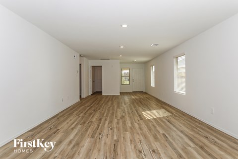 a spacious living room with hardwood floors and white walls