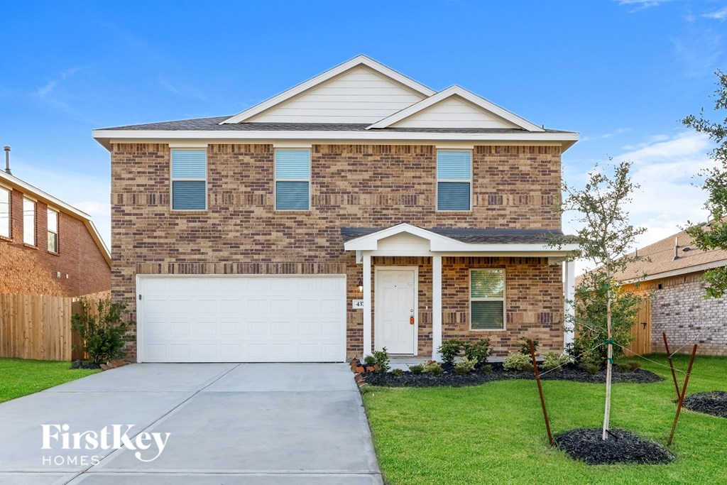 A house with a garage and a driveway in front.