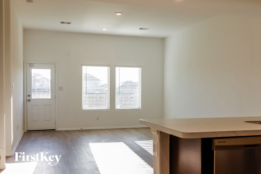 A white interior of a house with a door and windows.