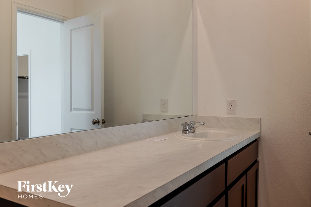 A bathroom with a sink and mirror.