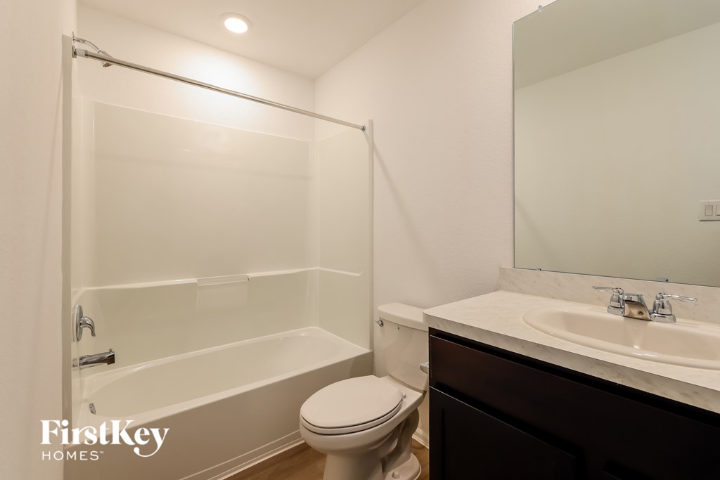 A white bathroom with a toilet, sink, and bathtub.