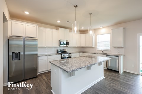 A kitchen with a granite countertop and stainless steel appliances.
