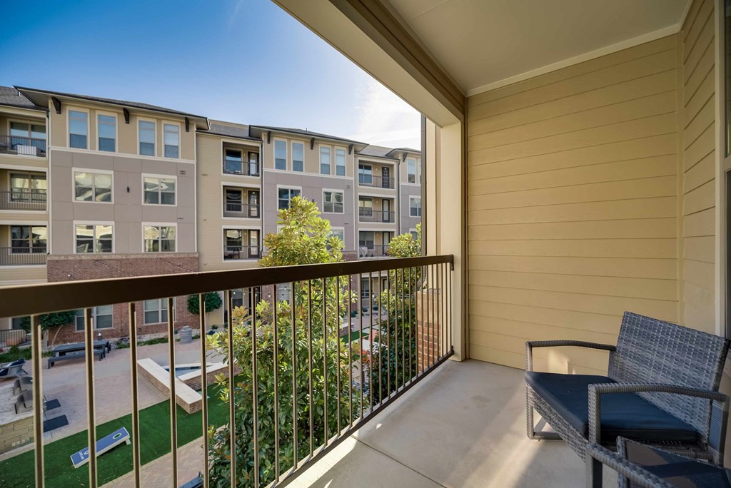 a balcony with a seating area and a view of an apartment building