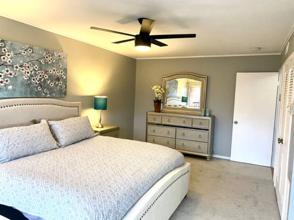 a bedroom with a bed and a ceiling fan