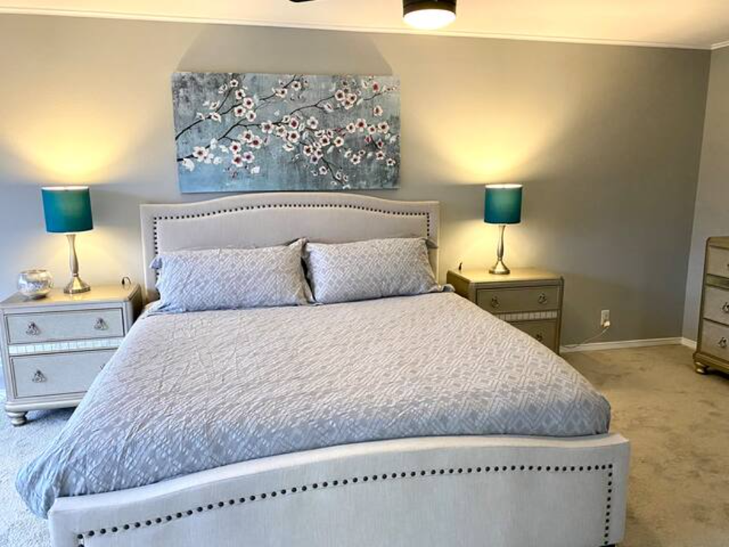 a bedroom with a bed and a painting on the wall