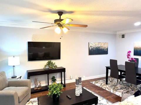 a living room and dining room with a ceiling fan