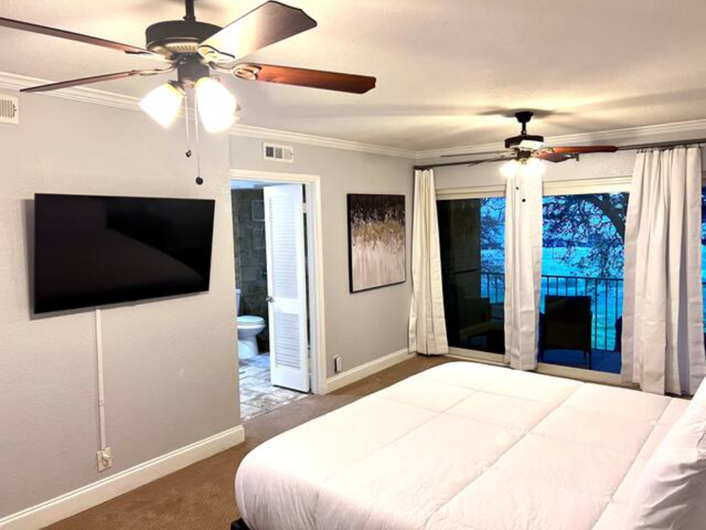 a bedroom with a large bed and a tv