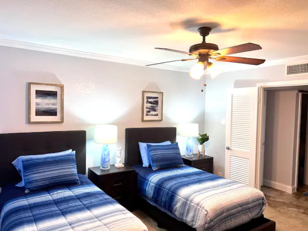 two twin beds in a bedroom with a ceiling fan