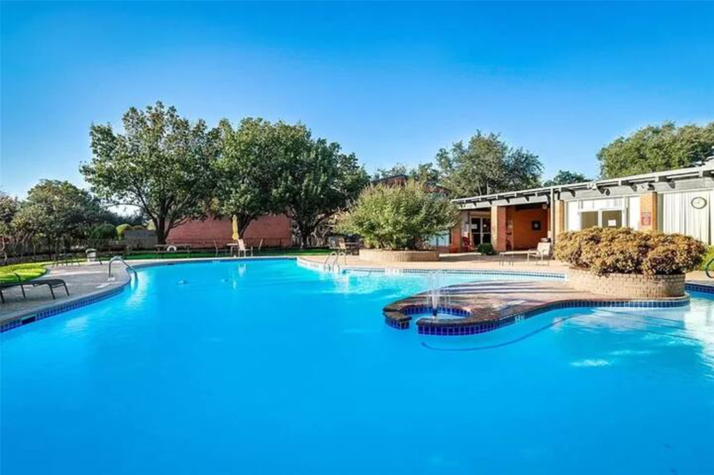a large swimming pool with a building in the background