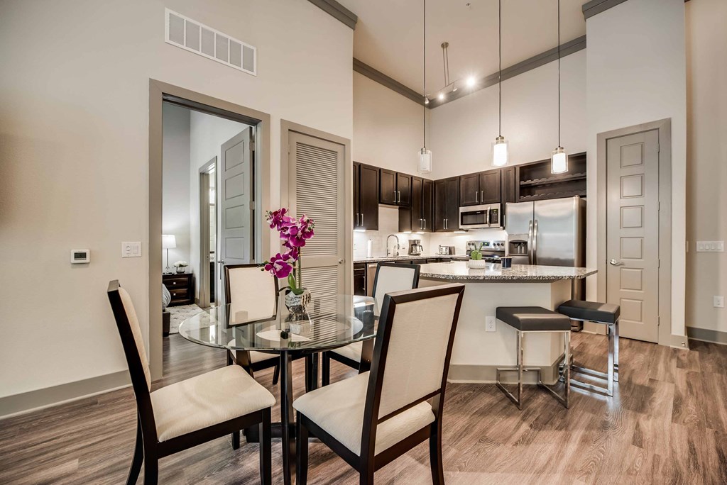 a dining room and kitchen with a table and chairs