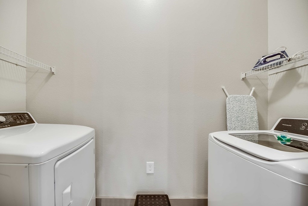 a white laundry room with a washer and dryer and a sink