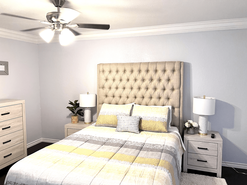 a bedroom with a bed and a ceiling fan