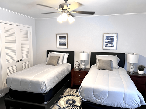 two twin beds in a bedroom with a ceiling fan