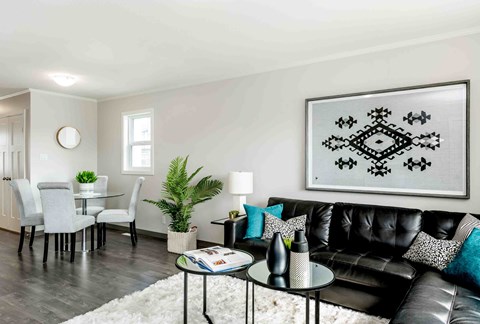 a living room with a black leather couch and a table