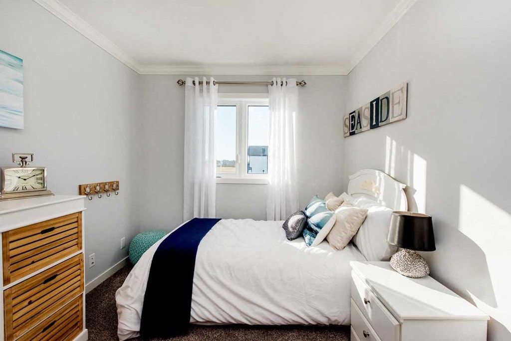 a small bedroom with a bed and a window