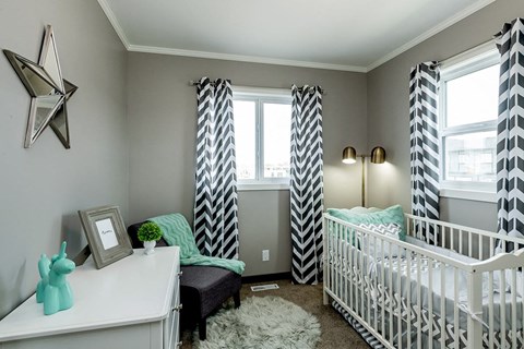 a gender neutral nursery with black and white curtains and a crib