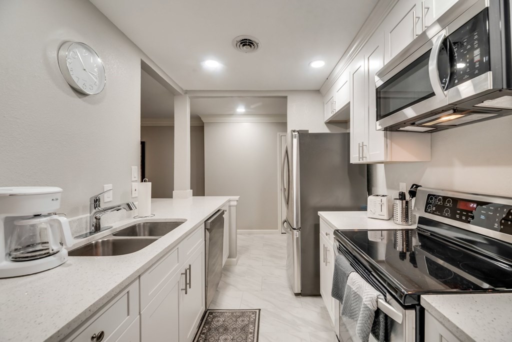 a kitchen with stainless steel appliances and white cabinets