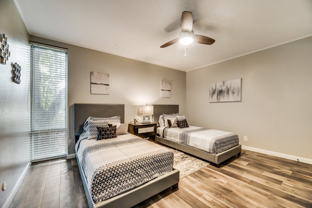 a bedroom with two beds and a ceiling fan